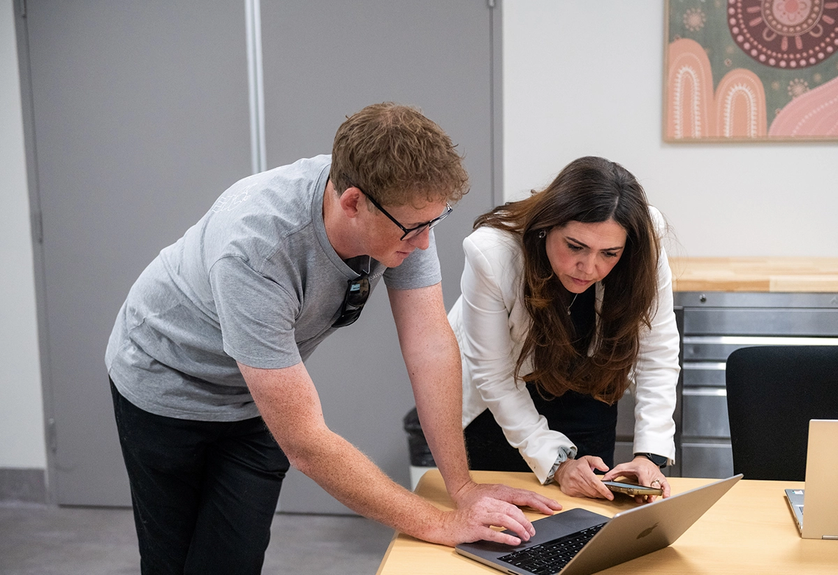 Two professionals collaborating at a laptop, demonstrating web design and digital services in a modern office setting.