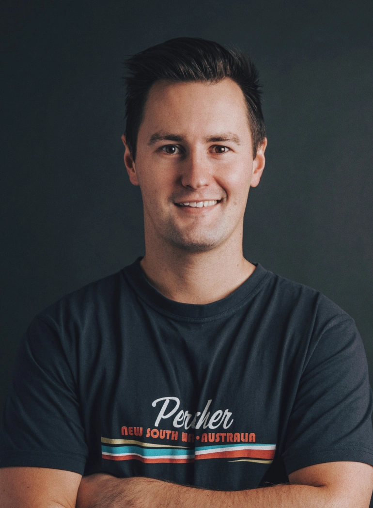 Man wearing Perth NSW Australia shirt against dark background, smiling at camera. Web design and digital services expert.