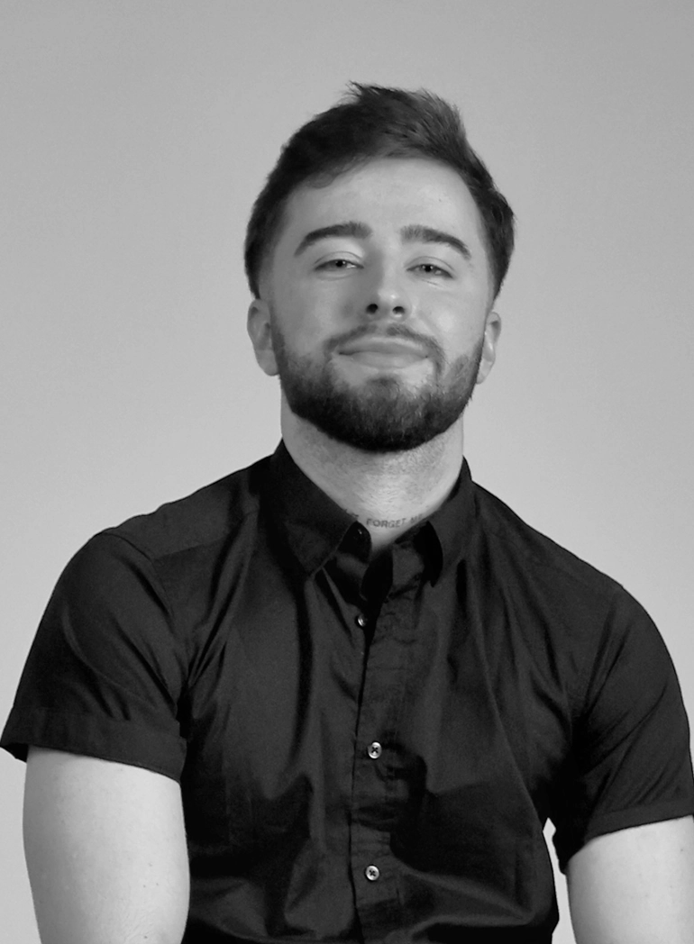 Black and white portrait of man in dark shirt against neutral background. Professional web design and digital services.